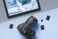 Top view digital SLR camera and tablet with a picture of the winter landscape: the concept of a winter holiday or training in