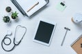 top view of digital tablet with blank screen stethoscope reflex hammer and paper cup of coffee on doctor Royalty Free Stock Photo