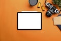 Digital tablet, camera, coffee cup and notebook on orange background at photographer workplace. Royalty Free Stock Photo