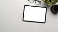 Top view digital tablet with empty screen, glasses, plant and coffee cup on white office desk. Royalty Free Stock Photo