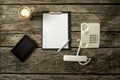 Top view of digital tablet, empy sheet of paper on black clipboard, pen, landline telephone with handset off the base and cup Royalty Free Stock Photo