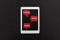 Top view of digital tablet and red speech bubbles with bullying, victim and apathy words on black background