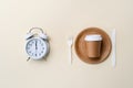 Top view of disposable dinnerware and alarm clock. Royalty Free Stock Photo