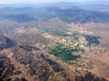 Top view of distant land surface with forests, mountains and fields