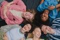 Top view of diverse group of friends having fun together at park lauging and lying on ground, Friendship and lifestyle Royalty Free Stock Photo