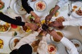 Top view of diverse hands of a Muslim family delicately grasp fresh dates, symbolizing the breaking of the fast during