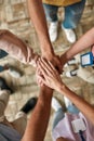 Top view of diverse young volunteers putting their hands on top of each other like a real team while standing in