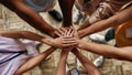 Top view of diverse young volunteers putting their hands on top of each other like a real team while standing in