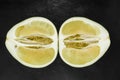 Top view of divided in the half pomelo fruit and placed on black stone background surface