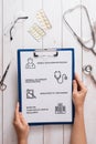 Top view of doctor desk with medical equipment at clinic/hospital. Stethoscope, prescription clipboard and bottle of pills on