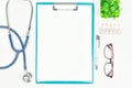 Top view of doctor desk table with stethoscope, eyeglass, drug and blank paper on clipboard with pen