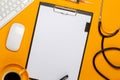 Top view of a doctor`s table with notepad and pen stethoscope, keyboard, prescription and pills, a cup of coffee on a yellow Royalty Free Stock Photo