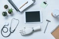 top view of doctor workplace with prosthetic arm stethoscope reflex hammer and digital tablet with blank screen Royalty Free Stock Photo