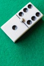 Top view of dominoes six and one on green mat in vertica Royalty Free Stock Photo