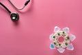 Top view daily doses pills in plastic container and a stethoscope on pink background Royalty Free Stock Photo