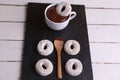 Top view of doughnuts a cup of hot chocolate with a doughnut dipping in and a wooden spoon Royalty Free Stock Photo