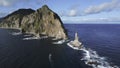 Top view of dramatic landscape of rocky island and lighthouse in sea. Clip. Cinematic fairy-tale landscape of rocky cape Royalty Free Stock Photo