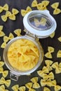 Top View of Dried Farfalle Pasta in Glass Jar with Some Scattered Around Royalty Free Stock Photo