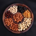 Top view on dried fruits and nuts on brown round tray. Cashew nuts, raisins, cranberry, almond and apricots on portion Royalty Free Stock Photo