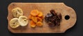 Top view, dried fruits on a rustic wooden board on a black background, top view. Overhead, from above, flat lay Royalty Free Stock Photo
