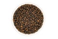 Top view of dried natural black pepper seeds in white ceramic cup on white background Royalty Free Stock Photo