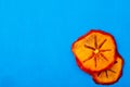 top view of dried persimmon slices isolated on blue background with copy space Royalty Free Stock Photo