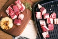 Top view of dried raw beef cubes placed on the metal and wooden trays with garlic on the side Royalty Free Stock Photo