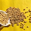 Top view of dried whole soybeans in a cup isolated on yellow background
