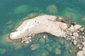 Top view drone shot of a stoney cliff of a coastline with two people