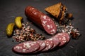 Top view of dry cured salami sausage with rye bread and pickled cucumbers Royalty Free Stock Photo
