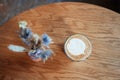 Top View Of Dry flowers decorating tabletop in cafe with small glas of flat-white coffee on