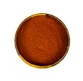 Top view of dry red chili pepper ground powder in a round wooden bowl isolated on white background.
