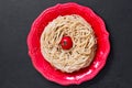 Top view durum wheat spaghetti on red plate on black background Royalty Free Stock Photo