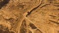 Top view of dusty sandy dirt road with wheels tracks and driving red truck. Scene. Truck moving and leaving a dusty Royalty Free Stock Photo