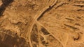 Top view of dusty sandy dirt road with wheels tracks and driving red truck. Scene. Truck moving and leaving a dusty Royalty Free Stock Photo