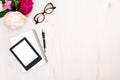 Top view E-reader, paper notepad, glasses and pen on wooden background. Flat lay woman accessories, feminine desk with e-book and Royalty Free Stock Photo