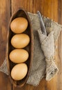 Easter background. Table setting for the holiday of Easter in a rustic style, burlap napkin, eggs, fork and knife on a wooden Royalty Free Stock Photo