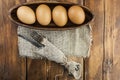 Easter background. Table setting for the holiday of Easter in a rustic style, burlap napkin, eggs, fork and knife on a wooden Royalty Free Stock Photo