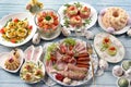 Top view of Easter breakfast with a plate of cold cuts, deviled eggs and vegetable salads