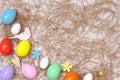 Top view of an Easter composition of painted eggs in bright juicy colors with a glossy texture of birds and flowers that lie on th