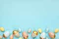 Top view of easter eggs colored with golden paint and differen colors. Blue background. Copy space Royalty Free Stock Photo