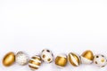 Top view of easter eggs colored with golden paint in differen patterns. Various striped and dotted designs. White background. Copy Royalty Free Stock Photo