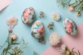 top view of Easter eggs with flower pattern and spring flowers on blue and pink background. Royalty Free Stock Photo