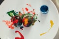 Top view of Easter eggs, painted by a child, placed on white plate. Royalty Free Stock Photo