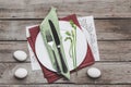 Top view of Easter table setting with cutlery, spring plant and Easter eggs on wooden table Royalty Free Stock Photo