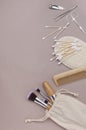 Top view of eco riendly beauty tools on the beige surface.Empty pace.Makeup brushes,comb,manicure set,sponge and ear brushes