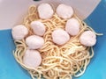 Top view of egg noodle clear soup topped with pork ball in bowl, Chinese food style