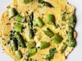 Top view on egg omelette with fresh green asparagus and parsley. Healthy vegan and vegetarian omelet for breakfast or