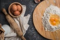 Top view eggs, dough, flour and rolling-pin on wooden table back Royalty Free Stock Photo