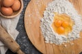 Top view eggs, dough, flour and rolling-pin on wooden table back Royalty Free Stock Photo